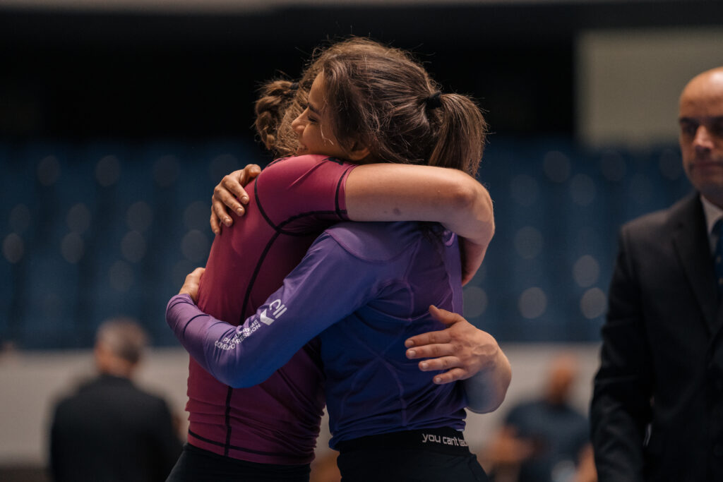Jiujitsu athlete, Nora Naomi hugging opponent